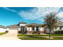 Charming single-story home with a well-manicured lawn, attached garage, and beautiful landscaping at 8261 Ivy Stark Blvd, Wesley Chapel, FL 33545