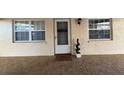 Charming front entrance features a tiled patio, decorative plant, and a 