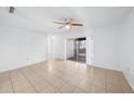 Bright living room featuring tile floors, a ceiling fan, and sliding glass doors to a balcony at 9031 Westchester Cir # 126, Tampa, FL 33604