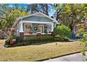 Inviting craftsman-style home with a cozy front porch and well-kept landscaping on a sunny day at 1015 E Caracas St, Tampa, FL 33603