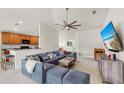 Open-concept living room with neutral tones, a plush sofa, and an adjacent kitchen area at 10209 Spanish Breeze Ct, Riverview, FL 33578