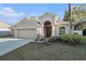 Inviting home featuring a well-kept lawn and a quaint entryway, adding curb appeal at 10623 Pearl Berry Loop, Land O Lakes, FL 34638