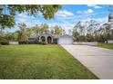 Inviting single-story home with a well-maintained lawn and classic white picket fence on a beautiful, sunny day at 1126 Oxbow Rd, Wimauma, FL 33598