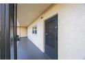 Exterior view of a unit entrance featuring a screen door, exterior window, and neutral colored wall at 11485 Oakhurst Rd # 111, Largo, FL 33774