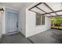 Welcoming entryway with a covered carport, gray front door, and textured white walls at 1368 Noell Blvd, Palm Harbor, FL 34683