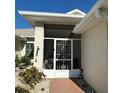 Welcoming screened-in front entry with decorative security door and manicured landscaping at 2021 E Del Webb Blvd, Sun City Center, FL 33573