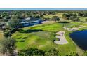 Aerial view of the golf course, featuring manicured greens, a sand trap, and a pond, offering a serene landscape at 23523 Gracewood Cir, Land O Lakes, FL 34639