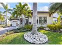 Landscaped front yard featuring lush grass, a large palm tree and other tropical plants at 3006 Christophers Watch Ln, Ruskin, FL 33570