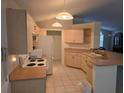 Functional kitchen featuring wooden cabinetry, white appliances, and tiled flooring at 3292 Dow Ln, Spring Hill, FL 34609