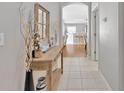 Inviting entryway with tiled floor, a decorative table with mirror, and a view into the kitchen and living area at 3412 Trapnell Ridge Dr, Plant City, FL 33567