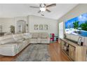 Comfortable living room with a large sectional sofa, wood floors, and a ceiling fan, perfect for relaxing at 3412 Trapnell Ridge Dr, Plant City, FL 33567