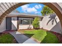 Arched entryway leading to a charming home with a well-kept front yard and inviting curb appeal at 3455 Overland Dr, Holiday, FL 34691