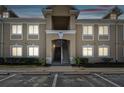 Two-story condo building with beige facade and well-lit windows at dusk at 6447 Cypressdale Dr # 202, Riverview, FL 33578