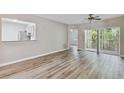Bright living room featuring stylish wood floors and a seamless kitchen view at 6447 Cypressdale Dr # 202, Riverview, FL 33578