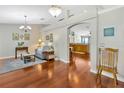 Cozy living room with hardwood floors, archway to kitchen, and elegant light fixtures at 703 June Lake Ln, Brandon, FL 33510