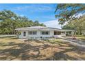 Well-maintained single-story home featuring a carport, brick accents, and neat landscaping at 7143 Sealawn Dr, Spring Hill, FL 34606