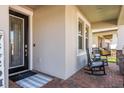 Cozy front porch with rocking chairs and brick flooring creates a welcoming entrance at 8766 Capstone Ranch Dr, New Port Richey, FL 34655