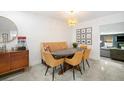 Cozy dining room with modern chairs, a built-in bench, stylish light fixture, and a view into the living area at 1110 S Pine Lake Dr, Tampa, FL 33612