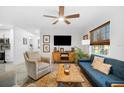 Comfortable living room featuring a ceiling fan, stylish decor, ample natural light, and modern furnishings at 1110 S Pine Lake Dr, Tampa, FL 33612