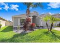 Attractive single-Gathering home showcasing manicured lawn, garden bed, and palm trees at 15414 Fire Rock Pl, Ruskin, FL 33573