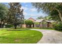 Beautiful home featuring a circular driveway, lush landscaping and mature trees at 16211 Villarreal De Avila, Tampa, FL 33613