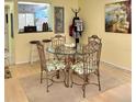 Cozy dining area with glass table, ornate chairs, and view to kitchen at 2205 Belleair Rd # A7, Clearwater, FL 33764