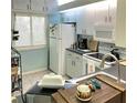 Bright kitchen features white cabinets, countertops, and appliances near window at 2205 Belleair Rd # A7, Clearwater, FL 33764
