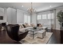 Bright living room featuring a chandelier, hardwood floors, and comfortable sectional sofa at 224 S Audubon Ave, Tampa, FL 33609