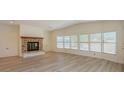 Bright living room featuring a brick fireplace, large windows, and light wood-look floors at 238 Pelican N Dr, Oldsmar, FL 34677