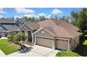 Well-maintained home with neutral colors, three-car garage, and landscaped front yard at 3033 Marble Crest Dr, Land O Lakes, FL 34638