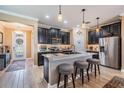 Modern kitchen with dark cabinets, stainless steel appliances, and a center island with seating at 31616 Parkland Bay Way, San Antonio, FL 33576