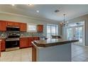 Kitchen featuring stainless appliances, tile backsplash, light countertops, and French doors leading to the patio at 4702 Corsage Dr, Lutz, FL 33558