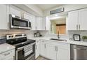 Modern kitchen with white cabinets, stainless steel appliances, and a stylish backsplash, offering a clean and functional space at 7310 Donna Dr, New Port Richey, FL 34652