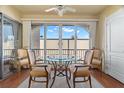 Bright dining area featuring a glass table, four chairs, and sliding glass doors to the balcony at 7701 Starkey Rd # 526, Seminole, FL 33777