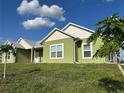 Side view of a charming single-story home featuring a well-manicured lawn and vibrant green exterior paint at 7735 Wauchula Rd, Myakka City, FL 34251