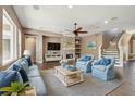 Bright living room features a cozy fireplace, a ceiling fan, and a staircase at 824 Islebay Dr, Apollo Beach, FL 33572