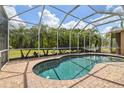 Relaxing screened-in pool with brick pavers, offering a private outdoor retreat surrounded by palm trees at 824 Islebay Dr, Apollo Beach, FL 33572