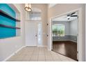 Inviting foyer with neutral walls, tile flooring, bright lighting, and an adjacent living space at 8714 Sandy Plains Dr, Riverview, FL 33578