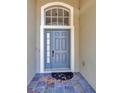 Welcoming front entrance featuring a blue door with sidelight and transom window, and stone tile at 8714 Sandy Plains Dr, Riverview, FL 33578