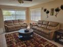 A living room with brown leather sofas, area rug, and lots of natural light from the windows at 10039 62Nd N Ave # 14, St Petersburg, FL 33708