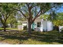 Cozy home with a teal door and a mature tree in the front yard, providing shade and curb appeal at 1225 9Th S Ave, St Petersburg, FL 33705