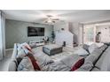 Inviting living room with large sectional sofa, entertainment center, and view into dining and entry area at 13549 Willow Bluestar Loop, Riverview, FL 33579