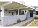 View of a front entry and carport with brick accents and hanging flower baskets at 1519 Delaware Ne Ave, St Petersburg, FL 33703