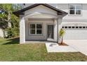 Inviting front porch with classic archway and stylish door, complemented by fresh landscaping at 16417 Lake Byrd Dr, Tampa, FL 33618
