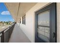 Condo balcony view with neutral stucco walls, black door and railing overlooking the neighborhood at 17580 Gulf Blvd # 316, Redington Shores, FL 33708