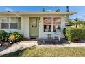 Close-up of the front entrance with a charming door, well-kept landscaping, and a cozy seating area at 1902 Dandridge St # 6, Sun City Center, FL 33573