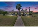 Charming single-story home at dusk with a well-maintained lawn, mature landscaping, and a walkway leading to the front door at 1902 Dandridge St # 6, Sun City Center, FL 33573