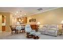 Open concept living room with white sofa, dining area, and view of the kitchen at 221 Shell Falls Dr, Apollo Beach, FL 33572