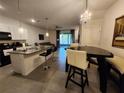 Open concept kitchen features a granite island with barstools, transitioning into the dining and living areas at 3267 Pleasant Willow Ct, Brandon, FL 33511