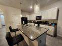 This kitchen has an island with a granite countertop, stainless steel appliances, and modern pendant lighting at 3267 Pleasant Willow Ct, Brandon, FL 33511